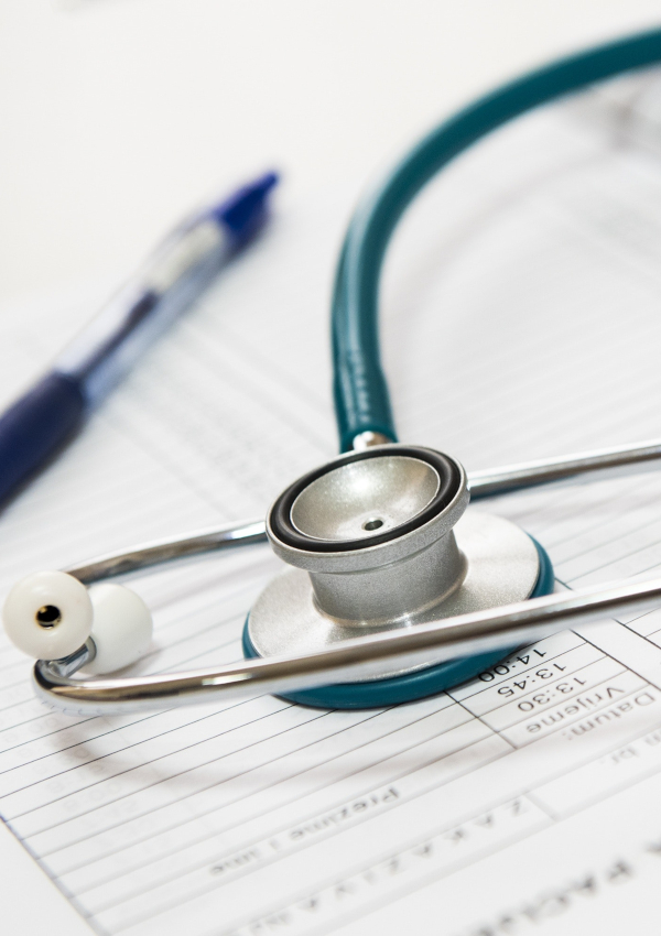 Stock photograph of stethoscope, pen, and paper.